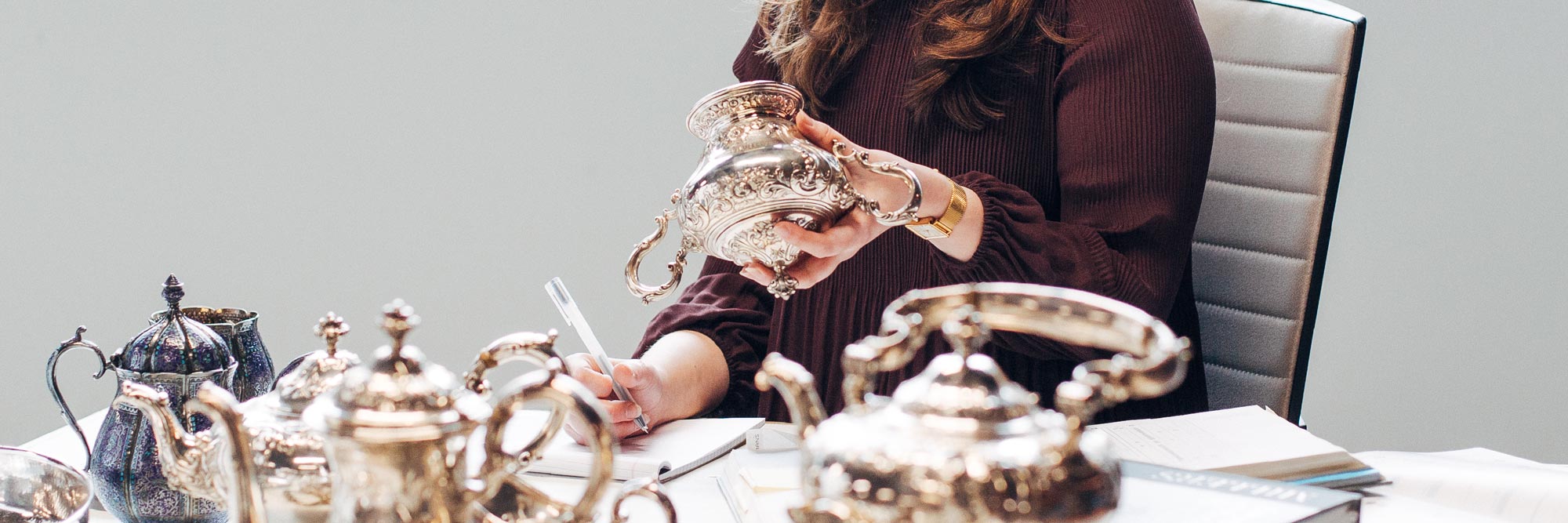 Freeman's expert examining a collection of silver