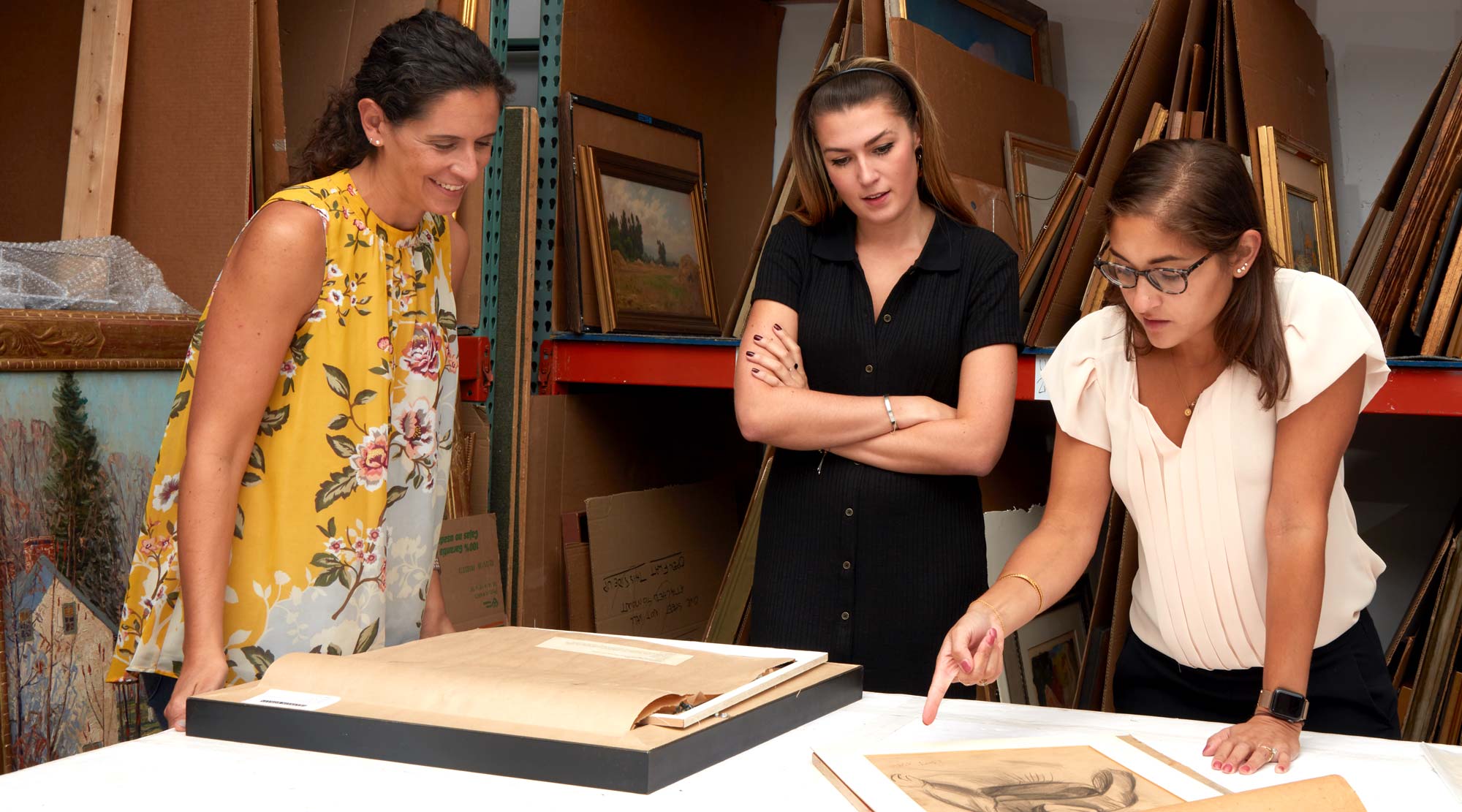 Freeman's specialists examining unframed artwork